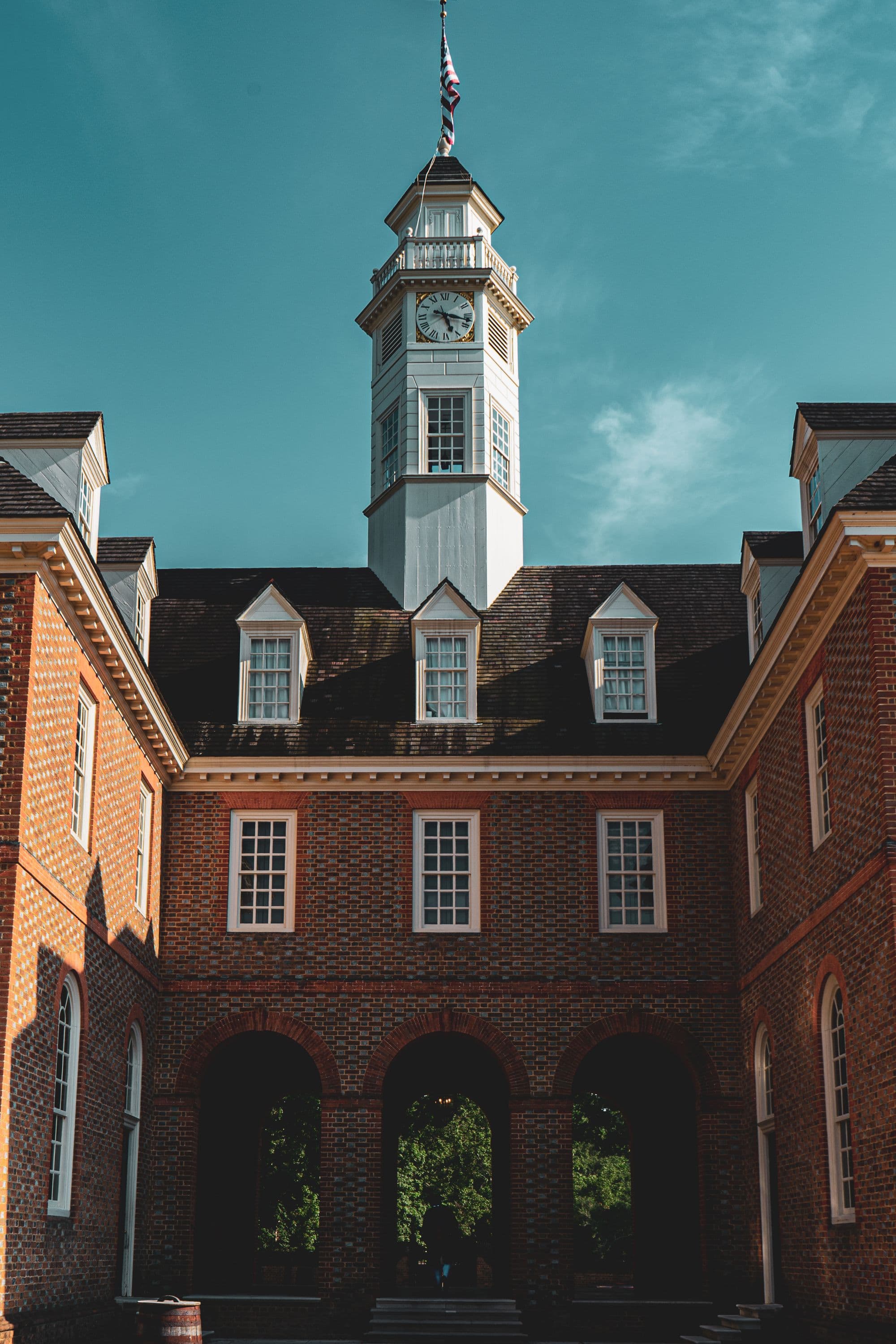 The brick façade and white clock tower of the Capitol in Colonial Williamsburg, Virginia
